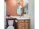 Cozy bathroom showcasing an earth tone painted wall, a toilet, single sink vanity and framed mirror at 12282 Bannock Cir # A, Denver, CO 80234
