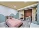 ' bedroom featuring pink bedspread, creative wall paint, and colorful decor accents at 12282 Bannock Cir # A, Denver, CO 80234