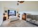 Serene bedroom with neutral tones, a large window, a crib, dresser, and a ceiling fan at 12282 Bannock Cir # A, Denver, CO 80234
