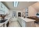 A well lit Kitchen features an island with a sink, white cabinetry and an adjacent living space at 12282 Bannock Cir # A, Denver, CO 80234