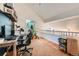 Bright office space featuring wood floors, a work desk, shelving and a view of the upper loft railing at 12282 Bannock Cir # A, Denver, CO 80234