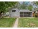 Home's backyard features green grass, large shade trees, and a covered carport at 3256 S Ogden St, Englewood, CO 80113