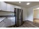 Bright kitchen with stainless steel refrigerator, granite countertops, and white cabinetry at 3256 S Ogden St, Englewood, CO 80113