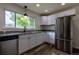 Modern kitchen featuring stainless appliances, granite counters, and ample white cabinets for storage at 3256 S Ogden St, Englewood, CO 80113