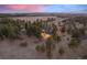 Aerial shot of an estate nestled among mature trees with a picturesque landscape and a vibrant sunset at 121 County Road 146, Elizabeth, CO 80107