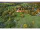 An aerial view showing a large home surrounded by lush green fields, and mature trees at 121 County Road 146, Elizabeth, CO 80107