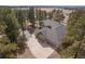 Stunning aerial view of a luxury home nestled among mature trees with expansive driveway at 121 County Road 146, Elizabeth, CO 80107