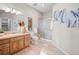 Well-lit bathroom featuring a single vanity, toilet, and glass-enclosed shower with beige tile at 121 County Road 146, Elizabeth, CO 80107