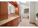 Bathroom with wooden cabinets, a framed mirror, beige countertops, and a glass shower at 121 County Road 146, Elizabeth, CO 80107