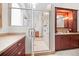 Bathroom featuring wood cabinets, a walk-in shower, beige countertops, and a framed mirror at 121 County Road 146, Elizabeth, CO 80107