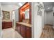 Bathroom with wooden cabinets, a framed mirror, beige countertops, and a glass shower at 121 County Road 146, Elizabeth, CO 80107