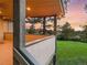 Cozy deck with wood railing offering a scenic view of mature trees and a lush green lawn at sunset at 121 County Road 146, Elizabeth, CO 80107