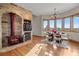 A dining area features a decorative fireplace, wood floors and a picturesque window view with plenty of natural light at 121 County Road 146, Elizabeth, CO 80107