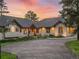 Inviting home exterior with stone accents, arched windows, and a well-maintained driveway, blending luxury with nature at 121 County Road 146, Elizabeth, CO 80107