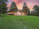 Spacious home exterior framed by mature trees and lush green grass in a serene countryside setting at 121 County Road 146, Elizabeth, CO 80107