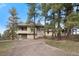 Exterior view of a multi-story home with stone accents and a gravel driveway at 121 County Road 146, Elizabeth, CO 80107