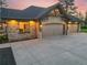 Well-lit garage featuring stone accents, carriage-style doors, and a spacious driveway, combining functionality and curb appeal at 121 County Road 146, Elizabeth, CO 80107