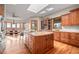 A view of the kitchen with wood cabinets, stone countertops, stainless steel appliances, skylight, and eat-in dining area at 121 County Road 146, Elizabeth, CO 80107