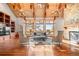 Open-concept living room features exposed wood beams, stone fireplace, and natural light through large windows at 121 County Road 146, Elizabeth, CO 80107