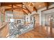Bright living room featuring a stone fireplace, wood beams, antler chandeliers, and hardwood floors at 121 County Road 146, Elizabeth, CO 80107