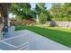 Manicured backyard featuring a small lawn, garden, mature trees, and a fenced perimeter at 6114 Miller St, Arvada, CO 80004