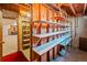 Basement storage room with wood shelving and visible ceiling joists and an attached room at 6114 Miller St, Arvada, CO 80004