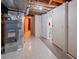 Unfinished basement with tile flooring, utility access, and a bathroom with a red towel at 6114 Miller St, Arvada, CO 80004