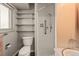 Compact bathroom with tiled shower and built-in shelving for storage at 6114 Miller St, Arvada, CO 80004