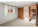 This bedroom includes gray walls, light carpeting, a window, and a closet with paneled doors at 6114 Miller St, Arvada, CO 80004