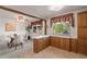 Open kitchen area with wood cabinets, adjoining dining space with natural light at 6114 Miller St, Arvada, CO 80004