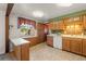 Bright kitchen with wooden cabinets, a window with valance, and a tiled floor at 6114 Miller St, Arvada, CO 80004