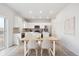 Well-lit kitchen and dining area featuring modern appliances, white cabinets, and ample countertop space at 19089 E 94Th Pl, Commerce City, CO 80022