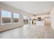Spacious open-concept living area featuring light wood floors, large windows, and access to a modern kitchen at 19089 E 94Th Pl, Commerce City, CO 80022
