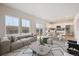 Bright, open living space with large windows, modern furnishings, and seamless flow to the dining and kitchen area at 19089 E 94Th Pl, Commerce City, CO 80022