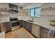Modern kitchen with stainless steel appliances, white countertops, gray cabinets, and open shelving at 315 E 112Th Dr, Northglenn, CO 80233