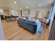 Bright open-concept living room featuring hardwood floors, a modern sofa, and a view to the kitchen at 315 E 112Th Dr, Northglenn, CO 80233