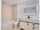 Modern bathroom featuring lighted mirror, stone tile detail, shower over tub and vanity at 8197 S Fillmore Way, Centennial, CO 80122