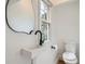 Modern powder room with a sleek sink, black faucet, unique mirror and bright natural light at 8197 S Fillmore Way, Centennial, CO 80122
