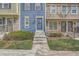 Exterior of a townhome with a vibrant blue facade and complementary stone accents with a small green space in front at 8197 S Fillmore Way, Centennial, CO 80122