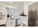 Modern kitchen with stainless steel appliances, white cabinetry, quartz countertops open to the main living space at 8197 S Fillmore Way, Centennial, CO 80122
