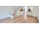 This open floor plan boasts a staircase, wood accent wall, kitchen with white cabinets and stainless appliances at 8197 S Fillmore Way, Centennial, CO 80122