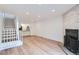 Open living room boasts hardwood floors, white walls, lots of light, a cozy fireplace, and an open staircase to bedrooms at 8197 S Fillmore Way, Centennial, CO 80122