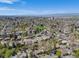 Expansive aerial view of a neighborhood with lush greenery and a mix of residential homes under a blue sky at 600 E Amherst Ave, Englewood, CO 80113