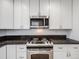Bright kitchen boasts stainless steel appliances, white cabinets, and beautiful dark granite countertops at 600 E Amherst Ave, Englewood, CO 80113