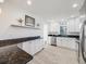 White kitchen with granite countertops, stainless steel appliances, and tile flooring at 600 E Amherst Ave, Englewood, CO 80113