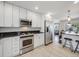 Modern kitchen featuring stainless steel appliances, white cabinetry, and bar seating at 600 E Amherst Ave, Englewood, CO 80113
