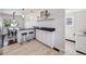 Updated kitchen with granite countertops, white cabinets, stainless appliances, and seating at the peninsula at 600 E Amherst Ave, Englewood, CO 80113
