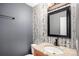 Charming half-bathroom features granite countertop, wood cabinet, and birch-themed wallpaper at 2791 S Bahama Ct, Aurora, CO 80013