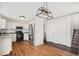 Open kitchen boasts stainless steel appliances, granite counters, white cabinetry and warm-toned hardwood floors at 2791 S Bahama Ct, Aurora, CO 80013