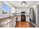 Updated kitchen featuring white cabinets, granite countertops, stainless steel appliances, and wood floors at 2791 S Bahama Ct, Aurora, CO 80013